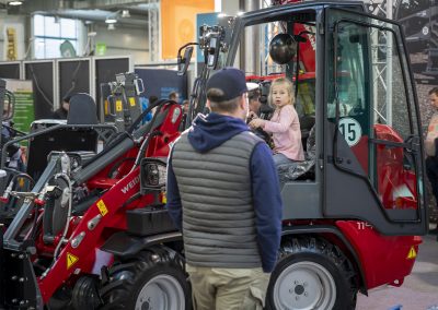 Kind sitzt in einem kleinen Fahrzeug auf einem Landtechnik Stand